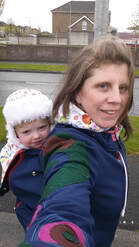 Rebeka Q Babywearing jacket with toddler in a back carry