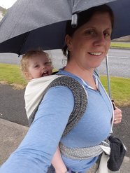 Photo of my daughter in a rucksack back carry in a Súsa Weaving handwoven wrap on a rainy summer's day in Ireland